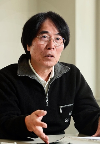 「こんなに魅力的な人間がいたことを覚えていてほしい」。写真集に込めた思いを語る岡村啓嗣さん＝神戸新聞社（撮影・中西幸大）