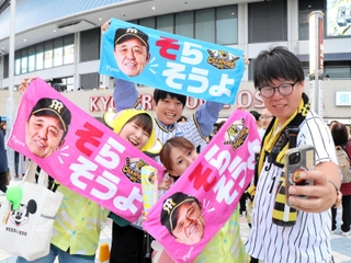 阪神の38年ぶり日本一を目前に、岡田彰布監督の「そらそうよ」タオルを掲げ、盛り上がる阪神タイガースファン＝大阪市西区、京セラドーム大阪前