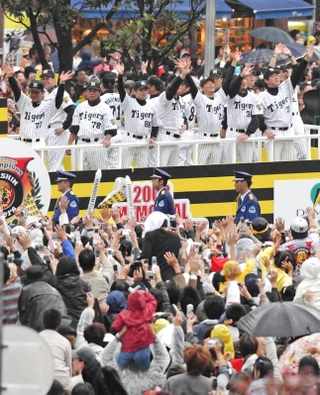 ２００３年の優勝パレードで沿道からのファンの声援に応える阪神ナインら＝神戸市中央区