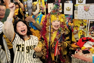 ノイジーの先制本塁打で喜び爆発させる引田孝子さん（右）と常連客ら＝５日夜、尼崎市西難波町６
