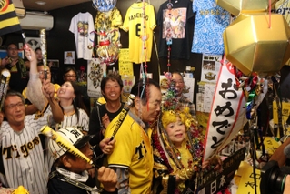 ３８年ぶりの日本一を喜ぶ居酒屋「尼のトラのおばちゃんの店」店主の引田孝子さん（右）と常連客ら＝５日夜、尼崎市西難波町６、尼のトラのおばちゃんの店
