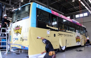 阪神タイガースの日本一を記念し金色にラッピングされるバス＝９日午前、尼崎市大庄川田町、阪神バス浜田車庫