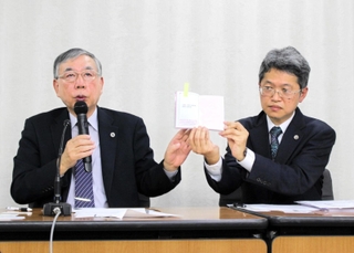 宝塚歌劇団の俳優が持つ「生徒手帳」を見せて、遺族の思いなどを語る代理人弁護士＝１０日午後、東京都内