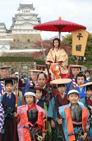 姫路城を背に記念撮影する、千姫に扮（ふん）した俳優の原菜乃華さん（奥）ら＝１１日午後、姫路市本町（撮影・辰巳直之）