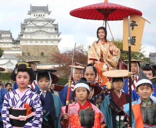 姫路城を背に記念撮影する、千姫に扮（ふん）した俳優の原菜乃華さん（奥）ら＝１１日午後、姫路市本町（撮影・辰巳直之）