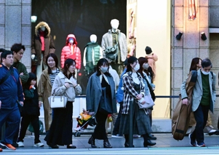 急な冷え込みに上着を着込んで歩く人たち。ショーウインドーも冬の装い＝１１日午後、神戸市中央区（撮影・中西幸大）