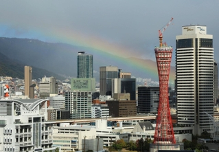 三宮のビル群を覆うような低い虹＝神戸市中央区東川崎町１から東を望む（撮影・笠原次郎）