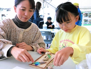 色とりどりのシーグラスや貝殻を使ってドアプレートを作る親子連れ＝神戸市中央区港島中町６