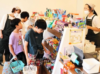 スタッフと会話しながら、駄菓子を選ぶ子どもたち＝西宮市南昭和町