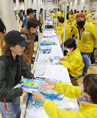 受け付けでアスリートビブスなどを受け取る神戸マラソンの出場者ら＝１７日午後、神戸市中央区港島中町６（撮影・長嶺麻子）