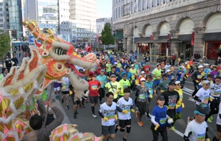 南京町前を通るランナーたちにエールを送る「龍舞」＝１９日午前、神戸市中央区（撮影・風斗雅博）