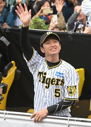 バスの上から沿道のファンに手を振る近本光司外野手＝２３日午前、神戸市中央区（撮影・高部洋祐）