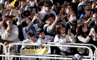 選手を乗せたバスが近づき、一斉にスマートフォンを掲げるオリックスファンら＝２３日午後、神戸市中央区（撮影・大森　武）
