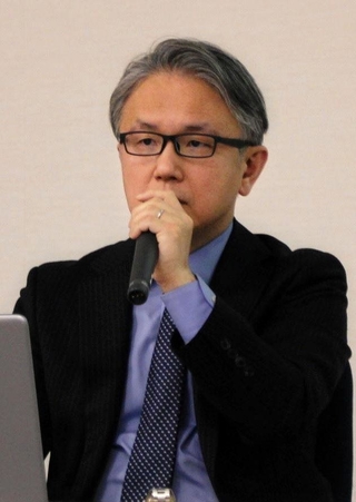 講演する神戸新聞社の霍見真一郎・報道部デスク兼編集委員＝２３日午後、横浜市中区
