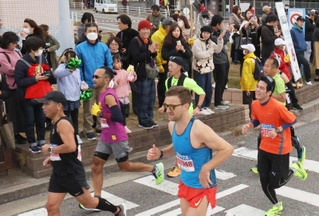「がんばれー」「ファイトー」。沿道の声援を受けながら快走するランナーたち＝神戸市垂水区