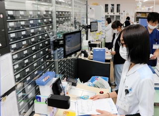 ピッキングロボットを導入した神戸市立医療センター中央市民病院薬剤部。左側の壁一面が装置で、薬が保管されている＝同市中央区港島南町２