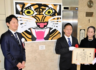 斎藤元彦知事（左）と作品の除幕式に臨む杉山統基さん（中央）、母の得美さん＝兵庫県庁２号館 