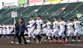笑顔で入場行進する三田松聖高校硬式野球部のＯＢら＝２９日午後、西宮市の甲子園球場（撮影・風斗雅博）