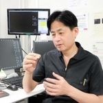 「重症患者は、激しい運動などを控え、無理をしないことが大切」などと話す当麻正直医師。手にするのはＴＡＶＩで使う人工弁＝尼崎市東難波町２、兵庫県立尼崎総合医療センター
