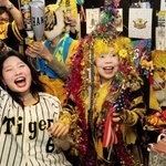 ノイジーの先制本塁打で喜び爆発させる引田孝子さん（右）と常連客ら＝５日夜、尼崎市西難波町６