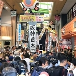 日本シリーズ用に点灯したマジックナンバーを「祝３８年ぶり日本一」の文字に差し替え、盛大に祝う阪神ファンら＝６日午前、尼崎市神田中通３（撮影・吉田敦史）