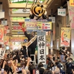 日本シリーズ用のマジックナンバーを「祝３８年ぶり日本一」に切り替え、盛大に祝う阪神ファンら＝６日午前、尼崎市神田中通（撮影・吉田敦史）