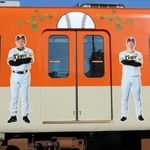 阪神タイガースの日本一を記念したラッピング電車。車体側面には岡田彰布監督や近本光司外野手らの等身大写真があしらわれている＝７日午後、尼崎市北城内、阪神電気鉄道尼崎車庫