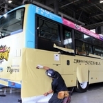 阪神タイガースの日本一を記念し金色にラッピングされるバス＝９日午前、尼崎市大庄川田町、阪神バス浜田車庫
