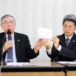宝塚歌劇団の俳優が持つ「生徒手帳」を見せて、遺族の思いなどを語る代理人弁護士＝１０日午後、東京都内