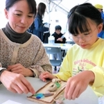 色とりどりのシーグラスや貝殻を使ってドアプレートを作る親子連れ＝神戸市中央区港島中町６