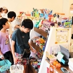 スタッフと会話しながら、駄菓子を選ぶ子どもたち＝西宮市南昭和町