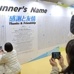 参加者の名前の一覧が記されたボード。ランナーたちが記念撮影をしていく＝１７日午後、神戸市中央区港島中町６、国際展示場（撮影・長嶺麻子）