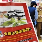 「大麻は違法薬物」と書いたチラシと啓発グッズを受け取る女性＝神戸市中央区布引町、ＪＲ三ノ宮駅