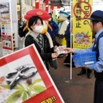 「大麻は違法薬物」と書いたチラシと啓発グッズを受け取る学生＝神戸市中央区布引町、ＪＲ三ノ宮駅