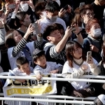 選手を乗せたバスが近づき、一斉にスマートフォンを掲げるオリックスファンら＝２３日午後、神戸市中央区（撮影・大森　武）