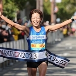 初優勝を飾り、笑顔でフィニッシュする地元・神戸市出身の堀江美里＝神戸市中央区