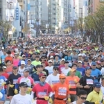 ビルが立ち並ぶ神戸の街中を走り出したランナー＝神戸市中央区