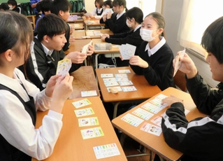 完成したカードゲーム「メディカルテット」で遊ぶ御影中の３年生＝神戸市東灘区御影中町５