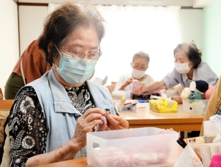 「ここに来るとできるんよ」。もくもくと編み続け、仕上げていく女性＝神戸市灘区曾和町２