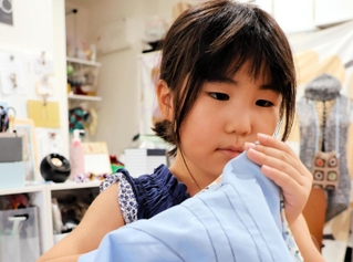 ミシンでつくったランチョンマットを仕上げる川本彩絵さん＝神戸市灘区曾和町２