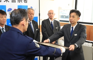 タクシーに乗り込んだ女性客が被害被害に遭うのを防ぎ、表彰される阪急タクシーの西田恵人さん（右）＝尼崎市潮江５、尼崎東署（撮影・吉田敦史）
