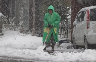 家の前で雪かきをする住民＝２１日午後、新温泉町芦屋（撮影・斎藤誉）