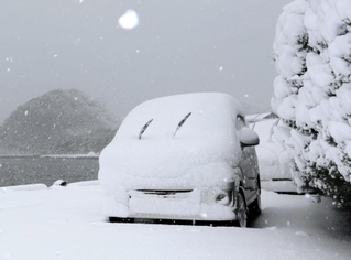 寒波の影響で降り出した雪に覆われた車＝２１日午前、豊岡市竹野町竹野（撮影・丸山桃奈）