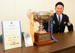 大会の優勝トロフィーなどを披露する岩田泰輝巡査長＝兵庫県警本部