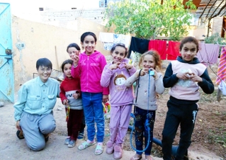 地震で被災し、テント暮らしを続ける子どもたちと佐々木美和さん（左端）＝１１月、モロッコ中部（神戸国際支縁機構提供）