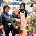 「クリスマス手しごと市」で自身が作った作品を眺める坂井洋子さん（右から２人目）と見守る平岡千里さん（右端）＝神戸市灘区曽和町２