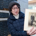 銘板に追加された義父母の写真を手にする佐々木美和子さん＝１７日午後、神戸市中央区加納町６、東遊園地（撮影・笠原次郎）