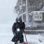 吹雪の中、雪かきする男性＝２１日午前８時５７分、兵庫県香美町香住区下浜（撮影・長谷部崇）