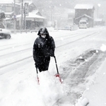 吹雪の中、雪かきする男性＝２１日午前８時５８分、兵庫県香美町香住区下浜（撮影・長谷部崇）