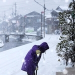 吹雪の中、雪かきする女性＝２１日午前８時４６分、兵庫県香美町香住区下浜（撮影・長谷部崇）